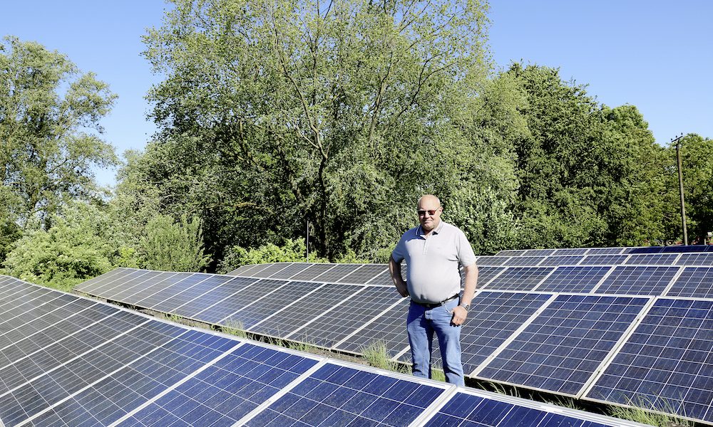 Mitarbeiter der Gemeindewerke Grefrath steht zwischen Solarmodulreihen